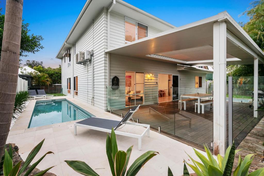 a backyard with a pool and a house at Elua Beach House in Byron Bay