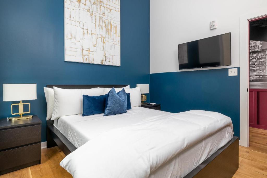 a bedroom with a large bed with a blue wall at Geranium Giant Close Proximity To Piedmont Park in Atlanta