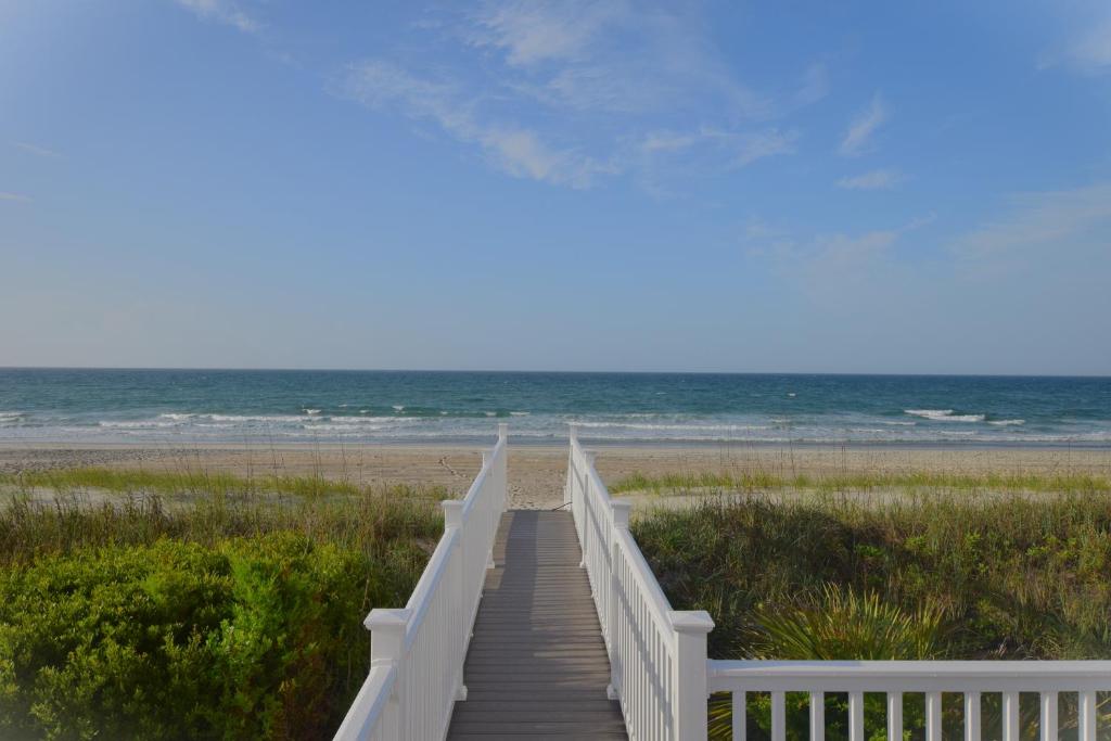 a wooden boardwalk leading to a beach with the ocean at Oceanfront vacation property - West in Emerald Isle