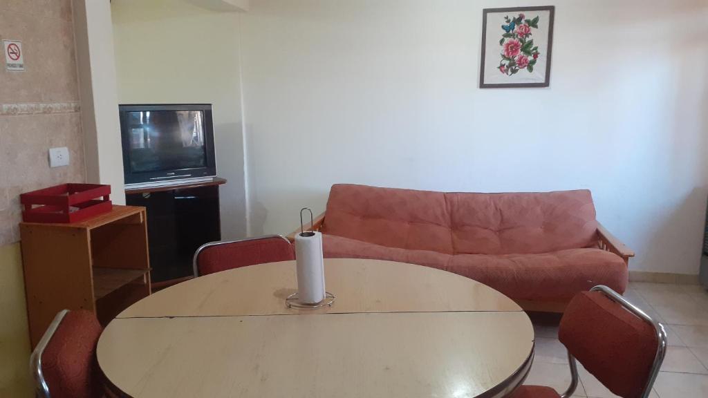 Departamentos La chacra في ريو جاليجوس: غرفة معيشة مع طاولة وأريكة