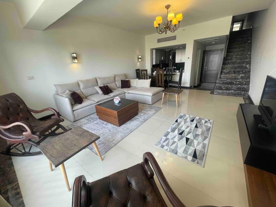a living room with a couch and a table at Entire duplex for a lovely vacation in Nyoum New Cairo in Cairo