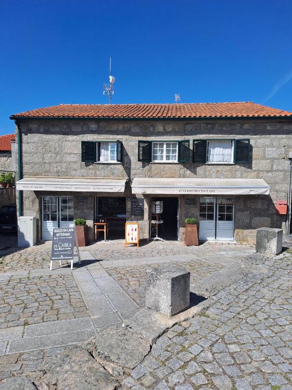 a large stone building with a sign in front of it at Casa Terreiro Da Lapa in Quintela