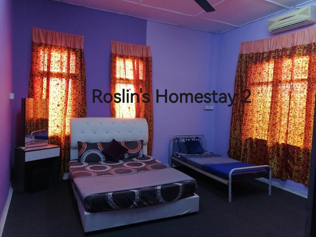 1 Schlafzimmer mit 2 Betten in einem Zimmer mit Vorhängen in der Unterkunft Roslin's Homestay 2 in Kota Bharu
