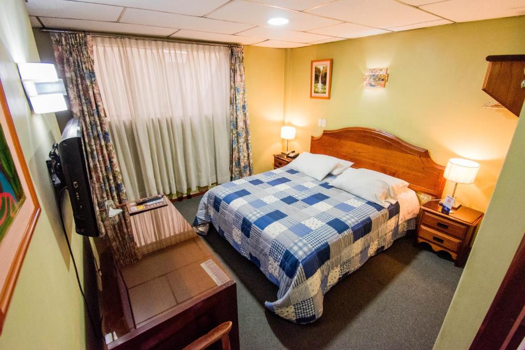 Postel nebo postele na pokoji v ubytování Grand Hotel Loja