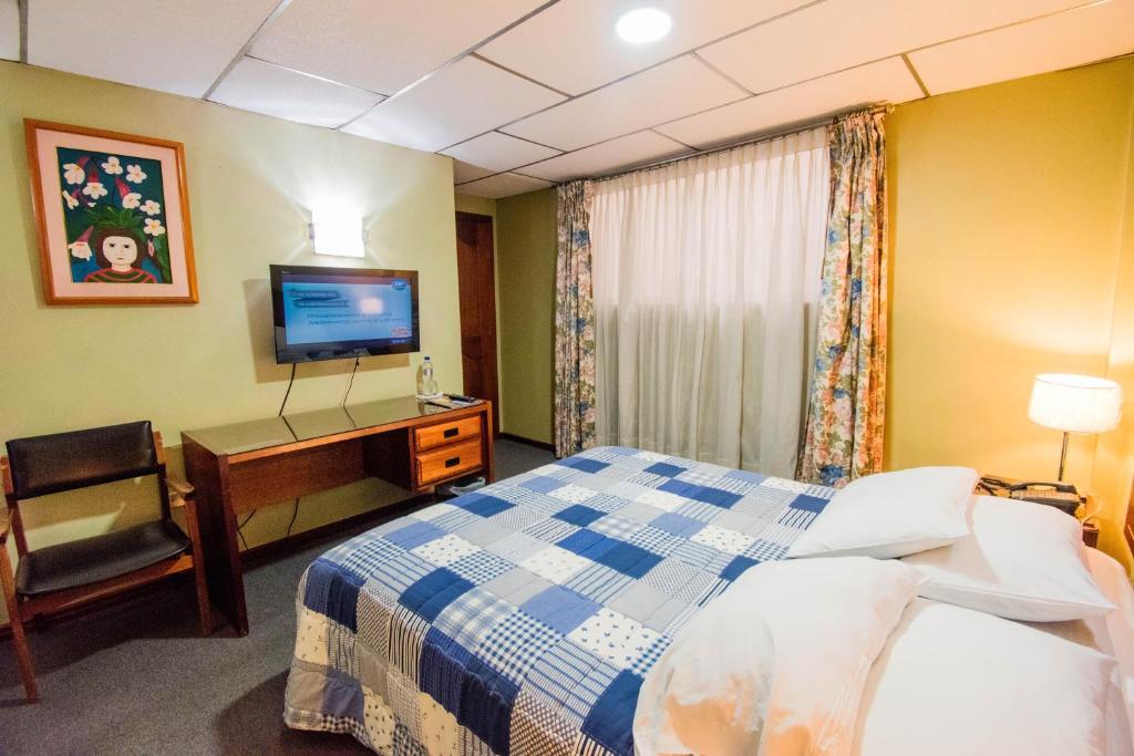 Postel nebo postele na pokoji v ubytování Grand Hotel Loja