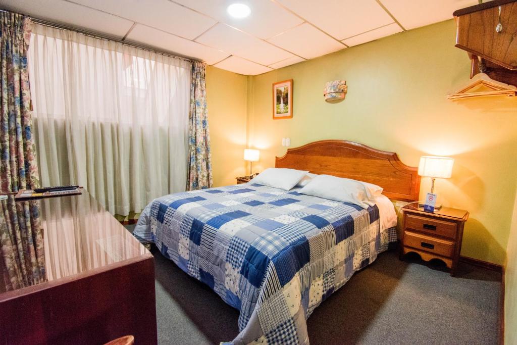 Postel nebo postele na pokoji v ubytování Grand Hotel Loja