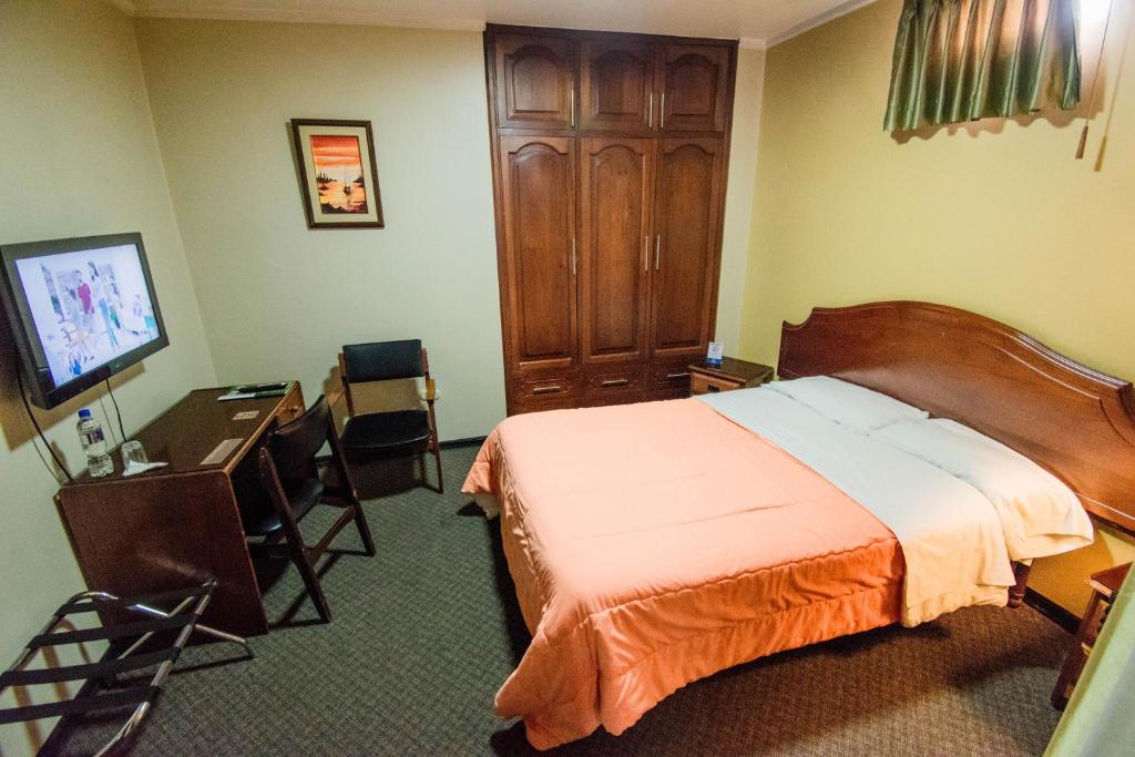 Postel nebo postele na pokoji v ubytování Grand Hotel Loja