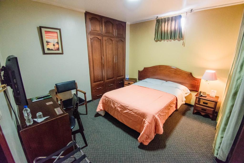 Postel nebo postele na pokoji v ubytování Grand Hotel Loja