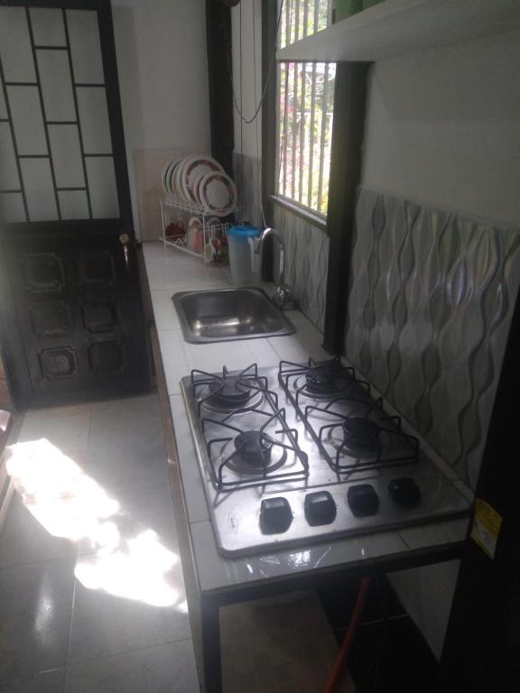 La cocina está equipada con fogones, horno y fregadero. en El Edén, en El Ocaso