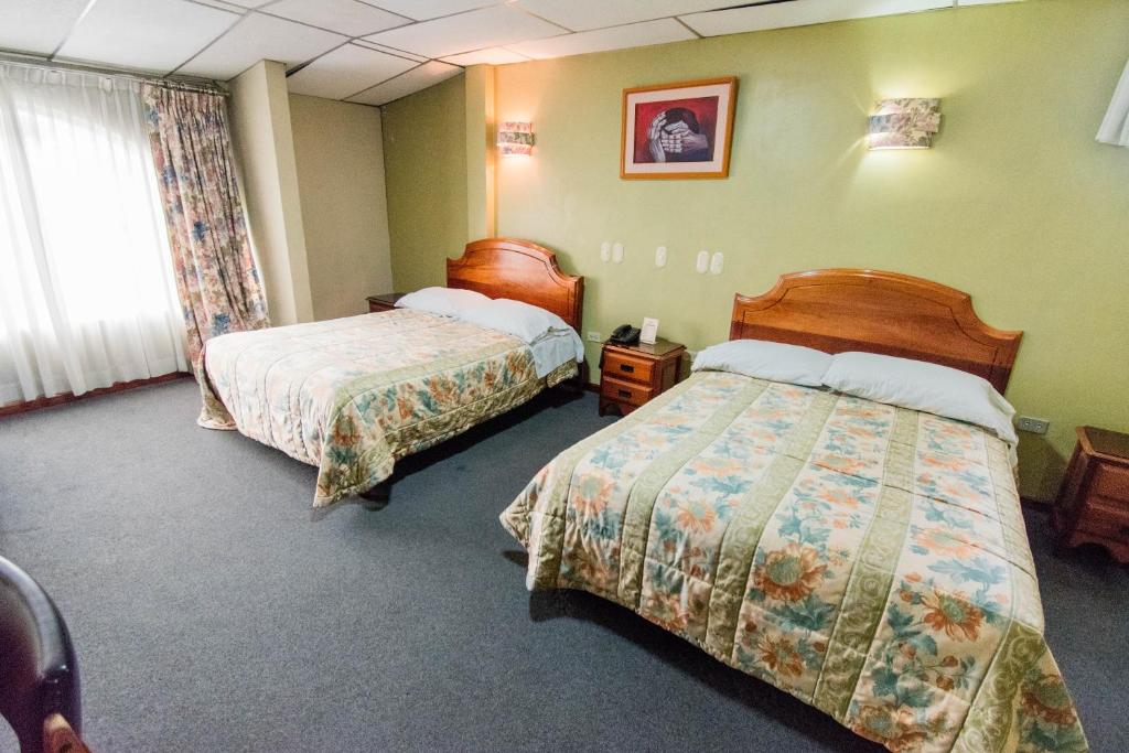 Postel nebo postele na pokoji v ubytování Grand Hotel Loja