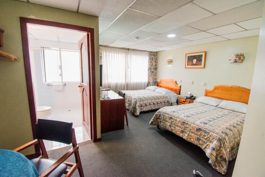 Postel nebo postele na pokoji v ubytování Grand Hotel Loja