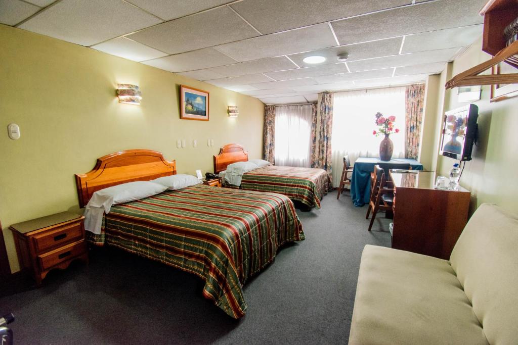 Postel nebo postele na pokoji v ubytování Grand Hotel Loja
