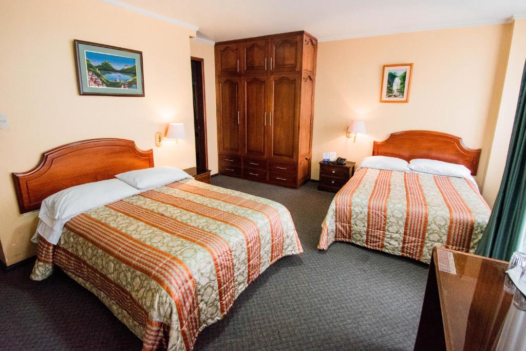 Postel nebo postele na pokoji v ubytování Grand Hotel Loja