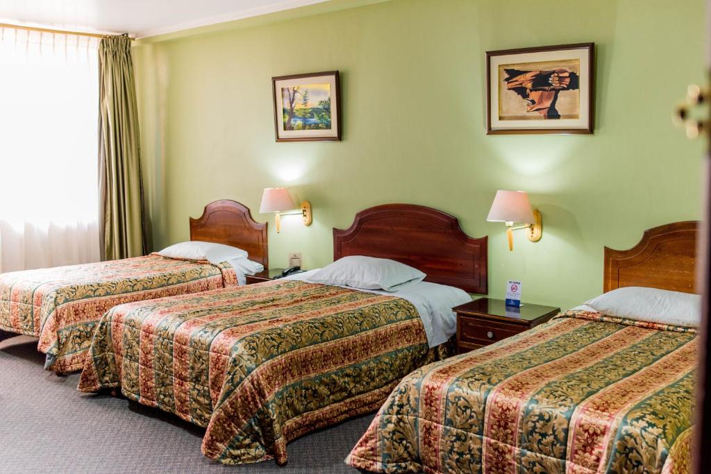 Postel nebo postele na pokoji v ubytování Grand Hotel Loja