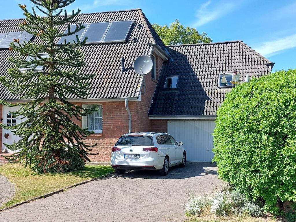 a white car parked in front of a house at Cosy Apartment Ostsee in Zierow with Terrace in Zierow