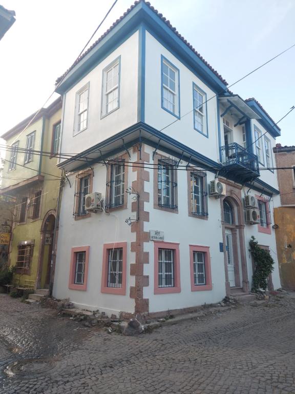 a white building with a cross on the side of it at Mimosa House Ayvalık in Ayvalık