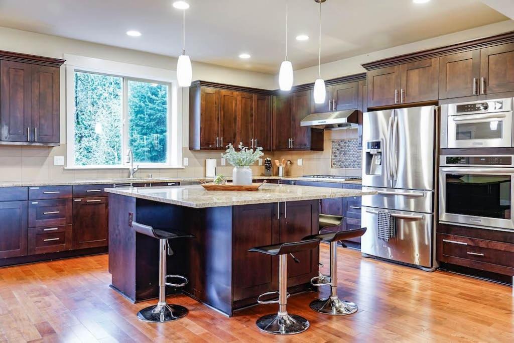 a kitchen with wooden cabinets and a large island with bar stools at Issaquah's spacious pet-friendly home near I90 in Issaquah
