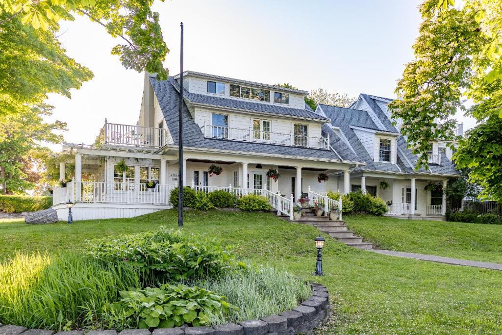 une grande maison blanche avec un toit bleu dans l'établissement Chestnut Inn, à Niagara Falls