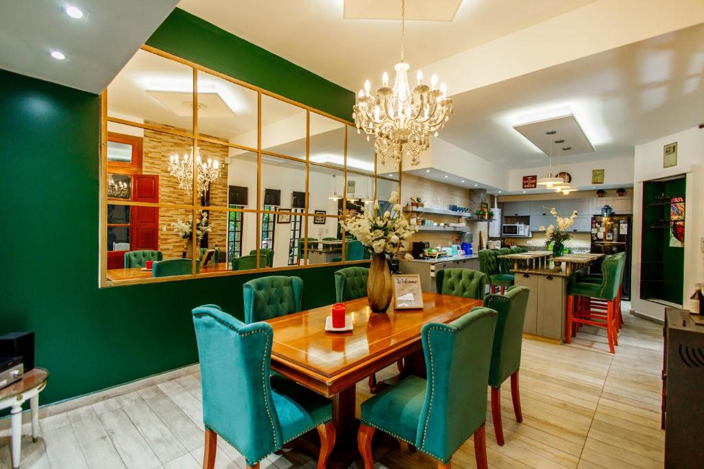 a dining room with a wooden table and green chairs at REGINA HOME in San Salvador de Jujuy