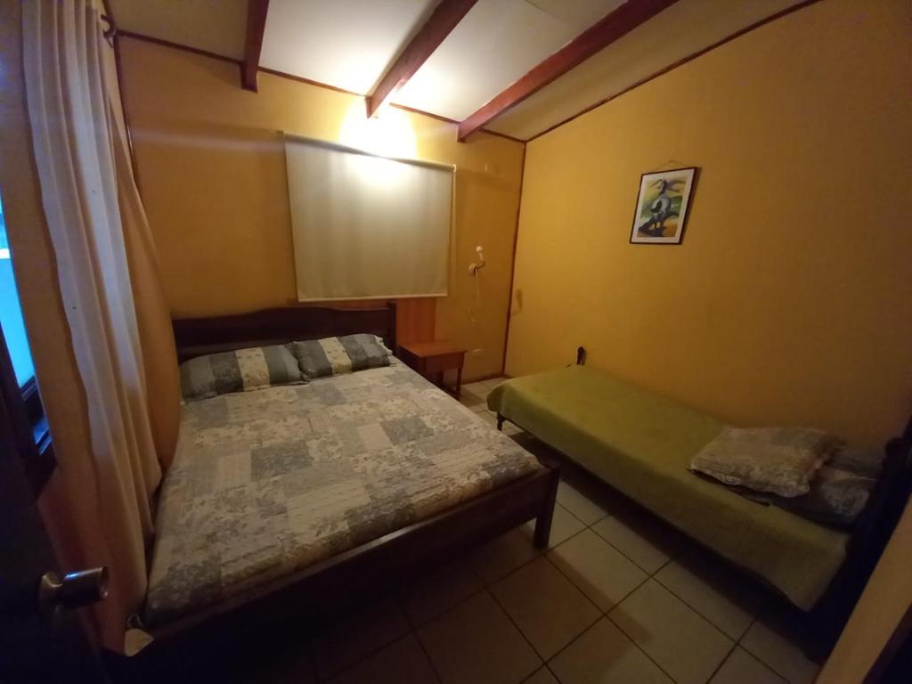 two beds in a small room with yellow walls at Cabañas Cristobal in Licán Ray