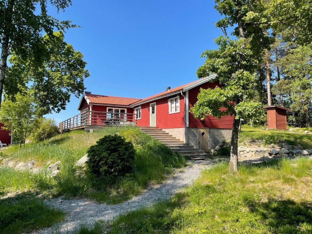 una casa roja en la cima de una colina en Holiday home ÅKERSBERGA V, en Åkersberga