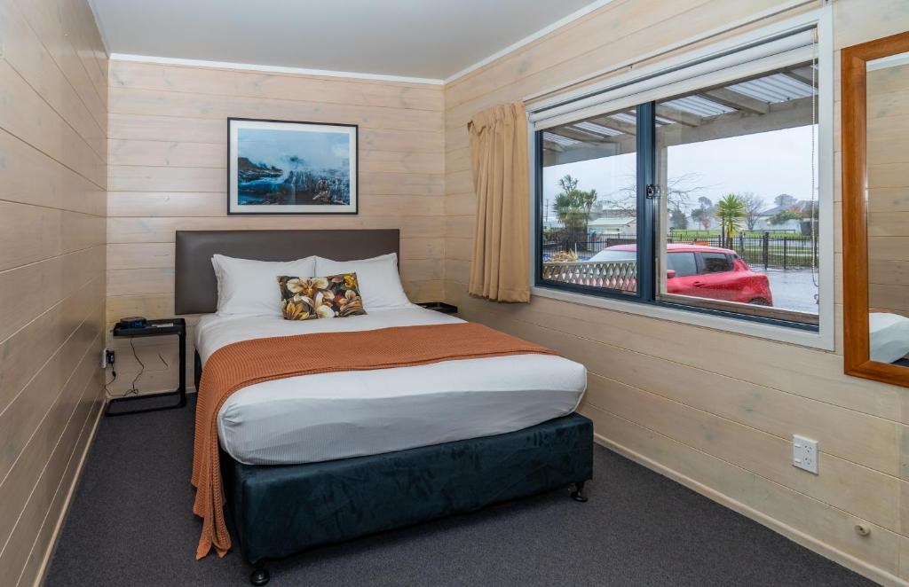 a small bedroom with a bed and a window at Tasman Holiday Parks - Rotorua in Rotorua