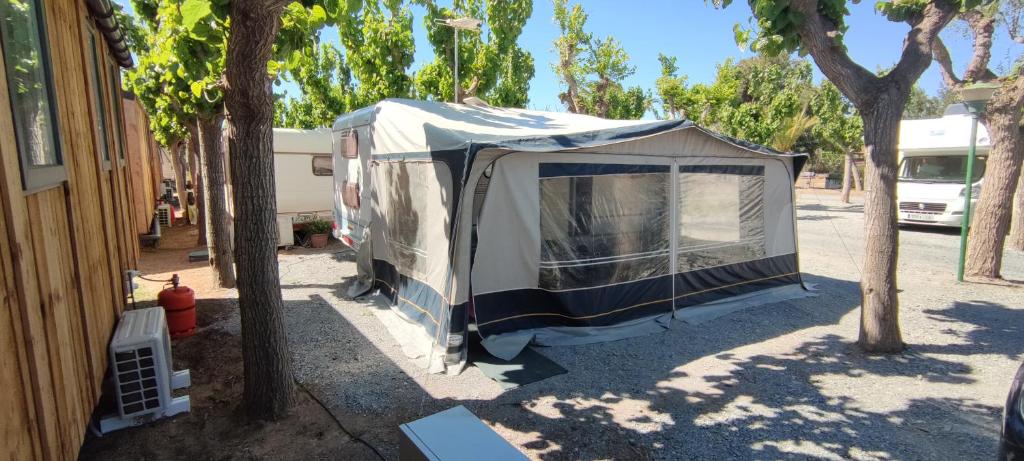 uma tenda está estacionada ao lado de um edifício em Hotel caravana Guadalupe em Tarragona