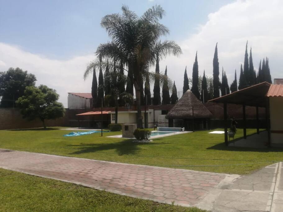 un parque con palmeras y un grupo de edificios en Casa de descanso alberca climatizada, en Atlixco