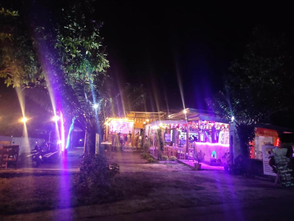 una escena nocturna de un mercado con luces coloridas en Achita Cottages, en Senaru