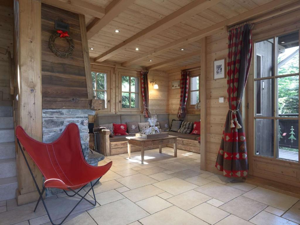 - un salon avec une cheminée et un fauteuil rouge dans l'établissement Chalet de Luxe 131m² Courchevel 1650 - 10 Pers., 5 Chambres, Proche Pistes et Centre, Spa, Parking - FR-1-631-147, à Courchevel