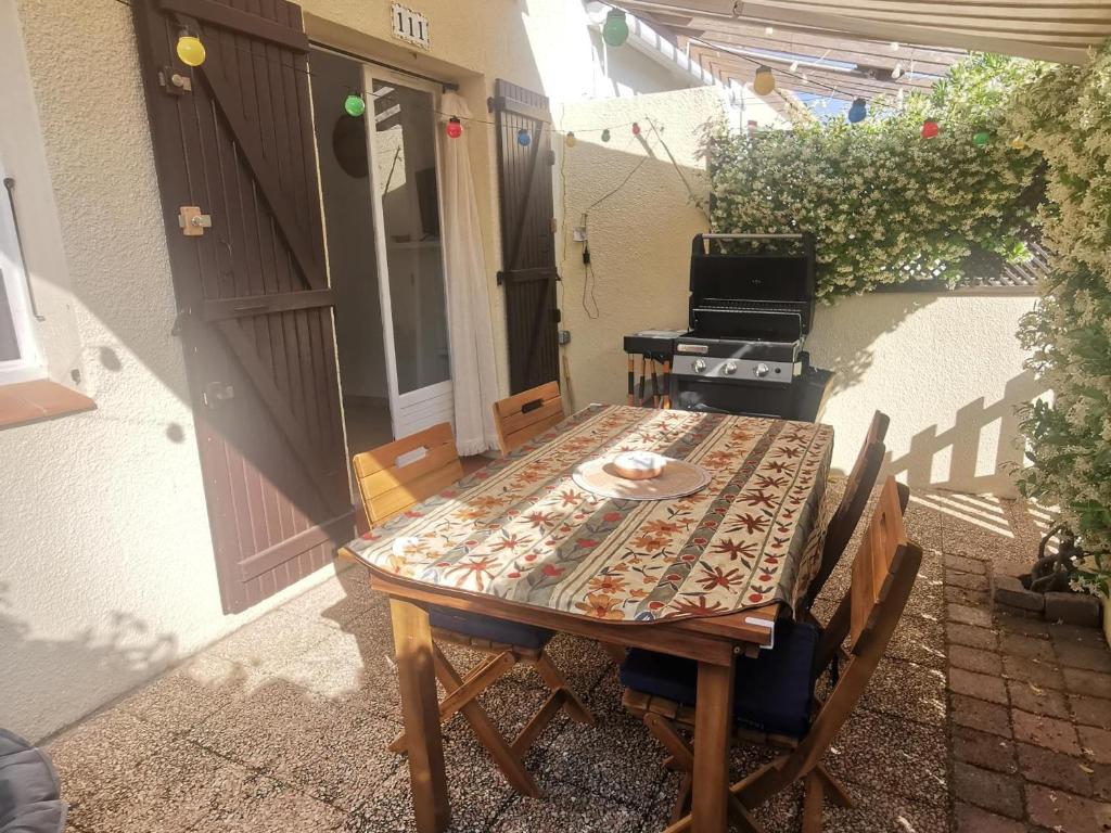 une table et des chaises assises à l'extérieur d'une maison dans l'établissement Pavillon lumineux avec terrasse à 500m de la plage, parking sécurisé, 6 couchages - FR-1-732-52, à Argelès-sur-Mer