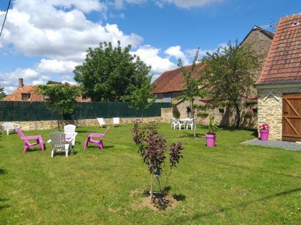 a yard with chairs and a tree in the grass at Charmante maison berrichonne restaurée avec jardin, proche de la Vallée de la Creuse et du Lac d'Éguzon - FR-1-591-445 in Maillet