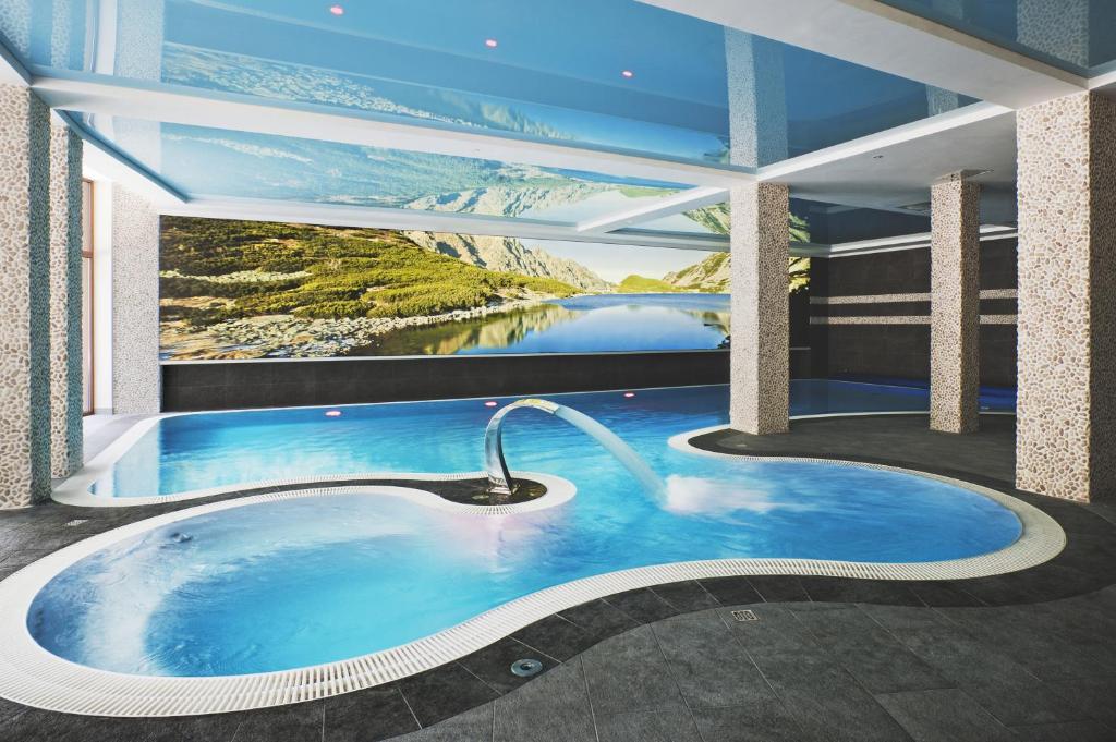 a hot tub in a room with a view of a lake at Hotel Żywiecki Medical SPA & Sport Żywiec in Żywiec