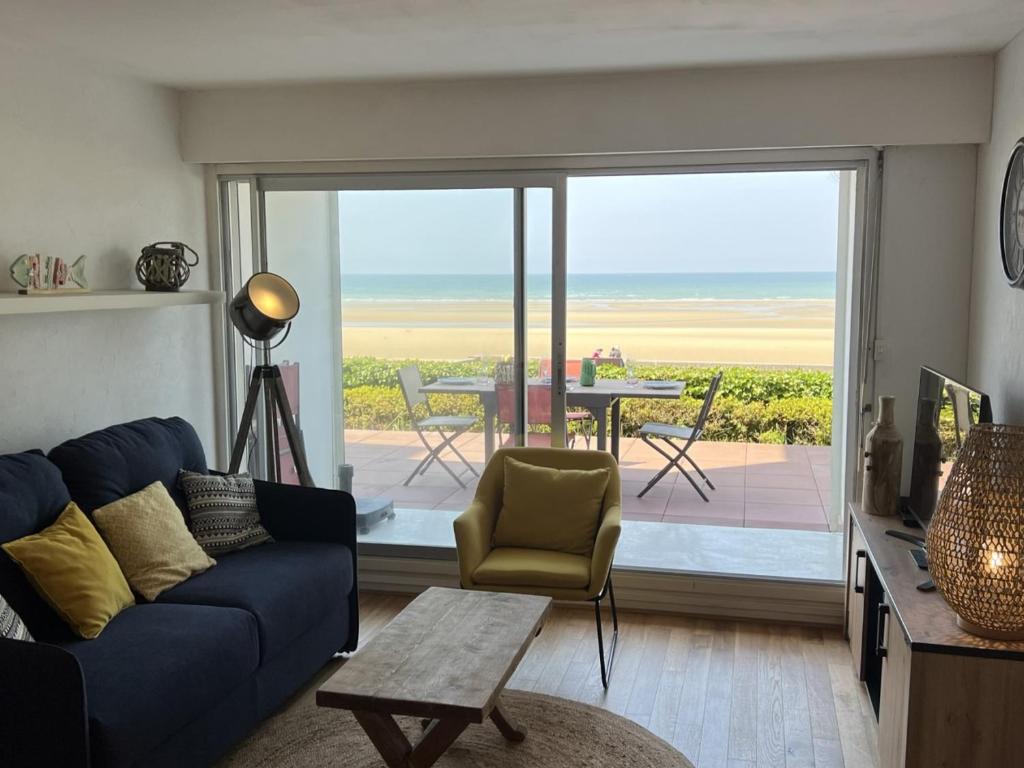 a living room with a blue couch and a view of the ocean at Appartement Cabourg, 2 pièces, 4 personnes - FR-1-487-258 in Cabourg