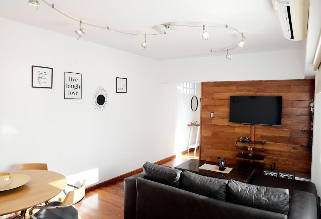 ein Wohnzimmer mit einem Sofa und einem TV in der Unterkunft Apartment 41 Melian in Buenos Aires