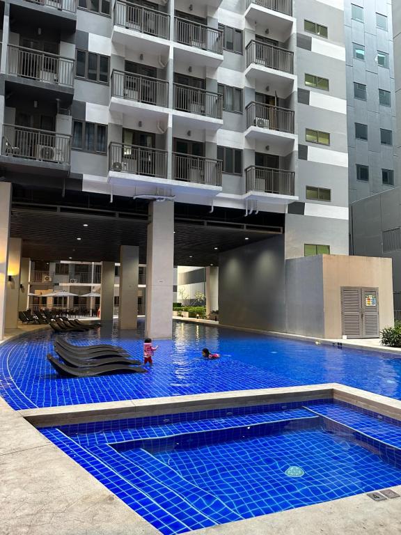 a swimming pool in front of a building at Luxe Staycation S Residences Tower 3 MOA in Manila