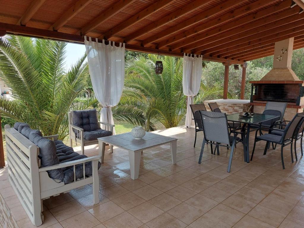 eine Terrasse mit einem Tisch, Stühlen und einem Kamin in der Unterkunft Andre House in Mesimvría