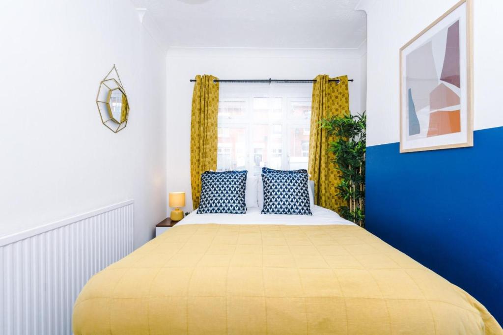 a bedroom with a large yellow bed with blue walls at Harley House in Parkside