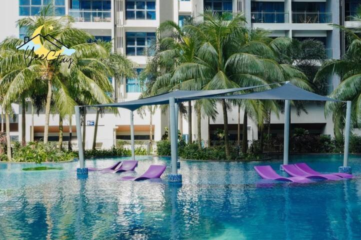 a hotel swimming pool with purple chairs and umbrellas at Atlantis Resindece Tvbox Video Game 5min To Jonker in Melaka
