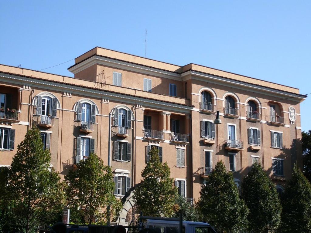 un grande edificio in mattoni con alberi di fronte di Serendipity a Roma