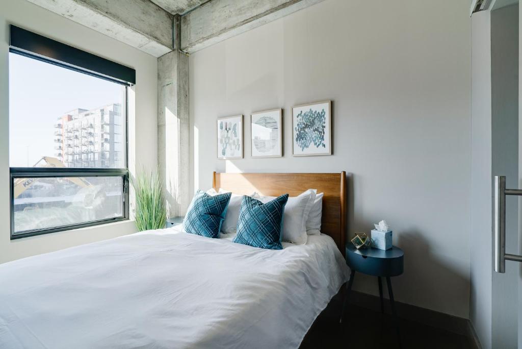 a bedroom with a large white bed with blue pillows at Sable 26 in Minneapolis
