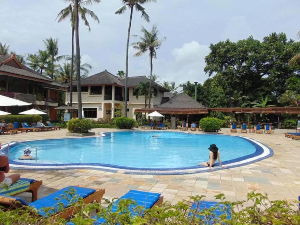 a woman in a pool at a resort at Beach Apartment inside Resort Walking Distance to the beach in Seminyak
