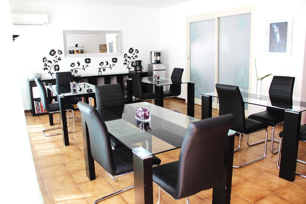 聖萊昂的住宿－B&B Villa Adriana，一间带桌子和黑色椅子的用餐室