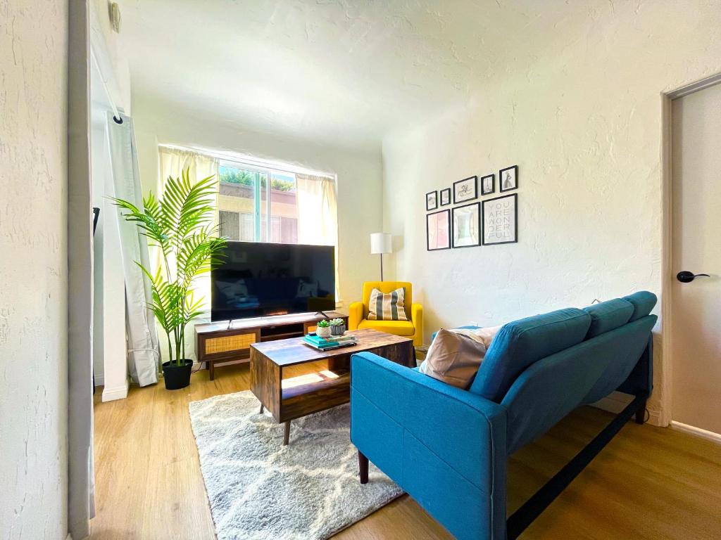 a living room with a blue couch and a table at Heart of Hollywood Apartment - 2Bed 2Bath in Los Angeles