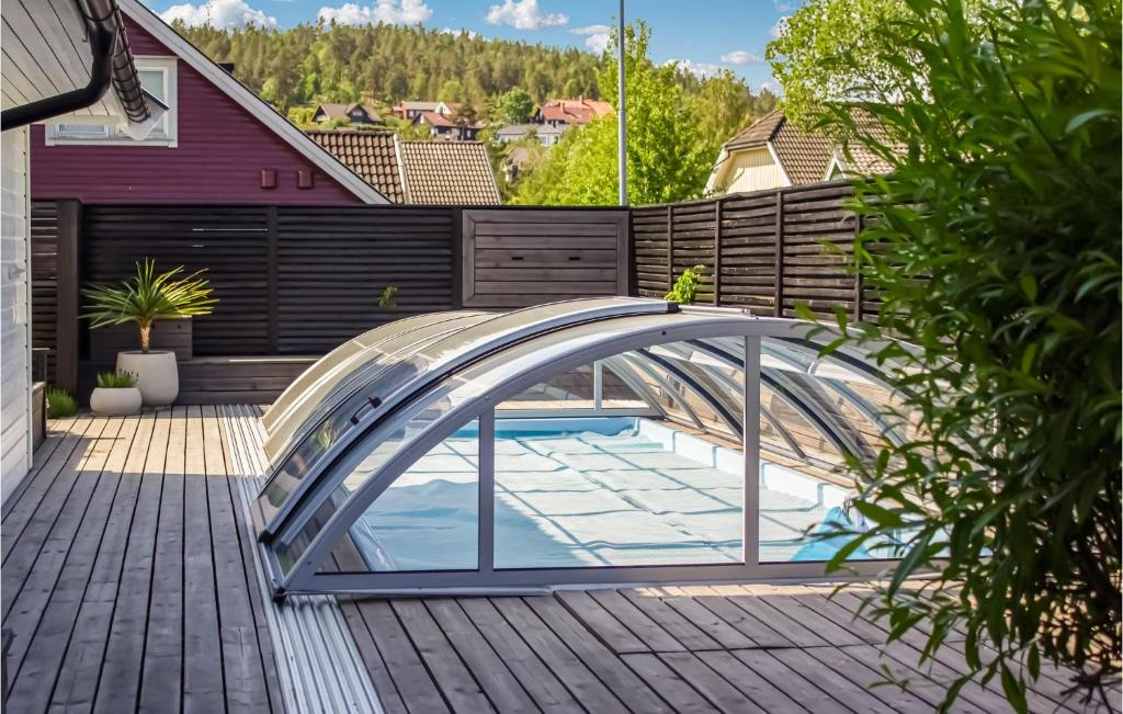 una piscina con un puente de cristal en un patio trasero en Beautiful Home In Skien With Private Swimming Pool, Can Be Inside Or Outside en Skien