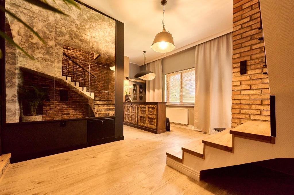 a living room with a fireplace and a brick wall at Apartamenty Na Skarpie in Płock