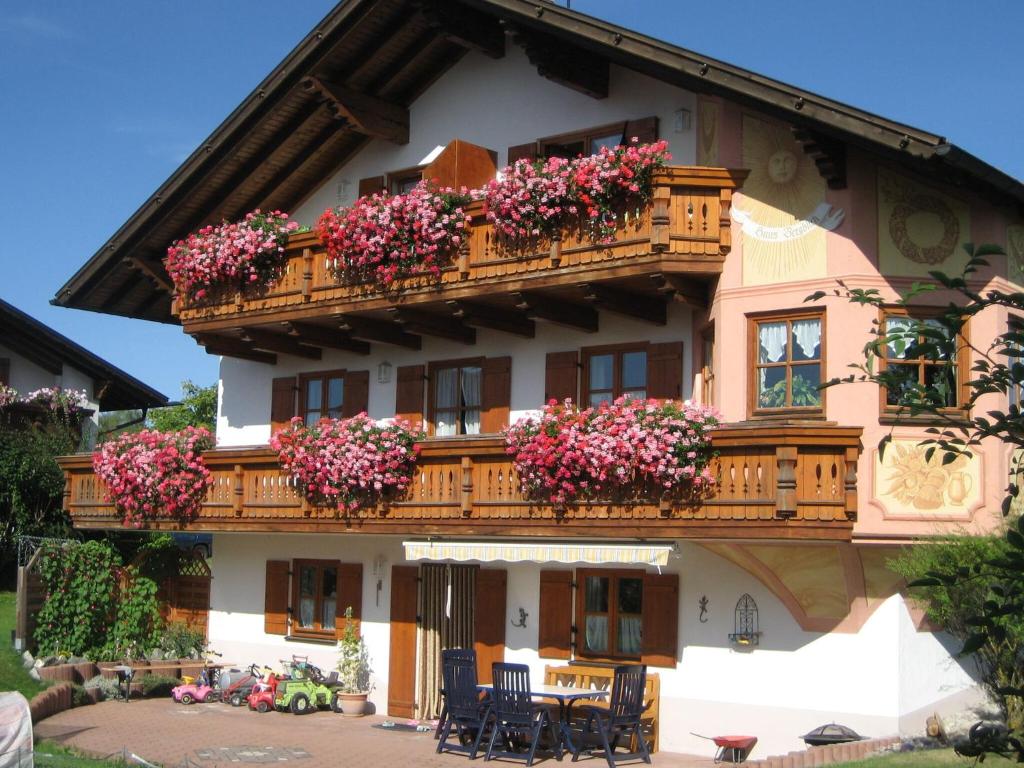 Apartment in the Allg u with view of the Bavarian Alps في Bernbeuren: مبنى عليه ورود على البلكونات