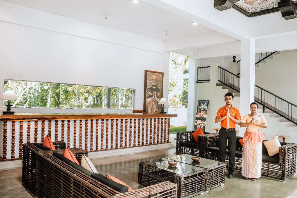 a man and a woman standing in a living room at Serendib Signature Resort in Digana