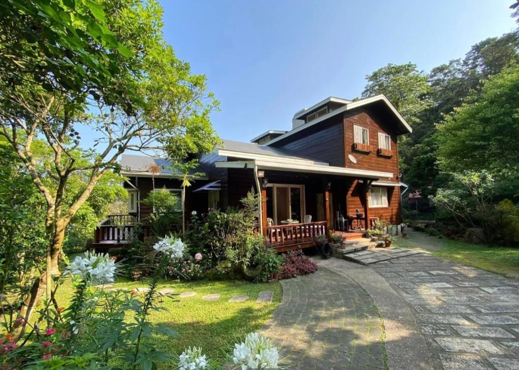 a wooden house with a pathway in front of it at Wen Qiao Villa in Nanzhuang