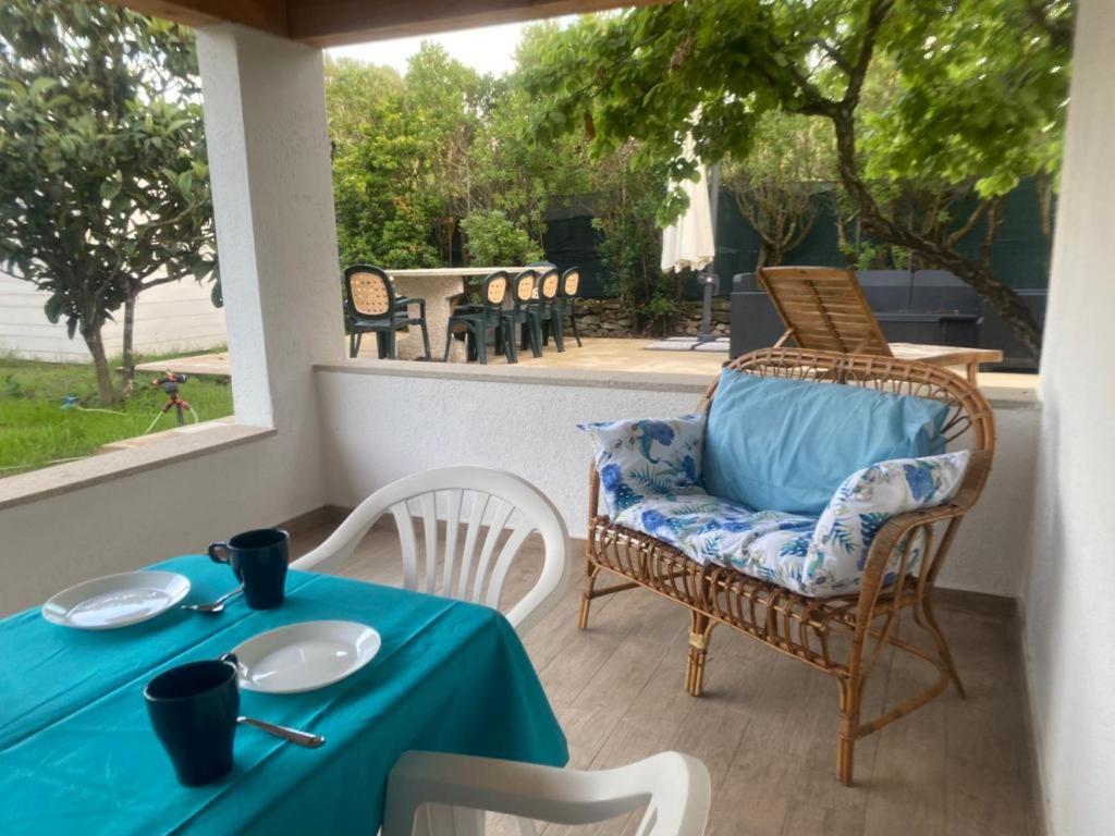 einen Tisch und einen Stuhl mit einem blauen Tischtuch auf einer Terrasse in der Unterkunft Il Nespolo Casa Vacanze a due passi dal mare in Olbia